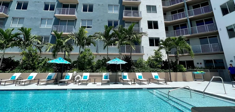 Palm-lined pool deck with cabanas and loungers at Centralis Residences Miami